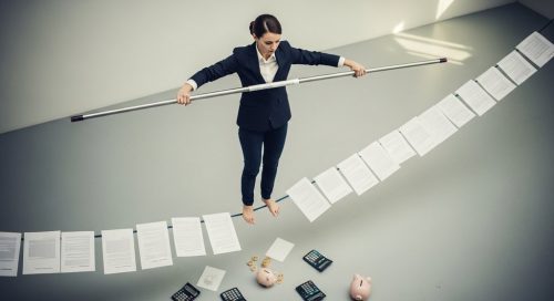 Ein Freelancer balanciert auf einem Seil aus Verträgen, um das Risiko der Scheinselbstständigkeit zu vermeiden.