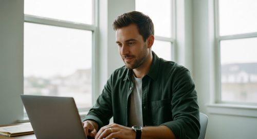 Selbstbewusster Freelancer managt seine Finanzen am Laptop mit einem passenden Geschäftskonto.